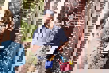 tech gives paper to homeowner